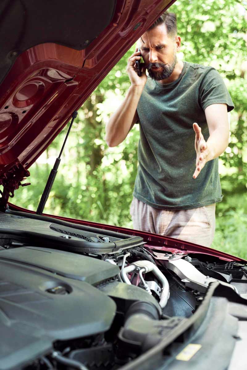 Junger Mann prüft Getriebeschaden bei Schrottauto Ankauf Lübeck